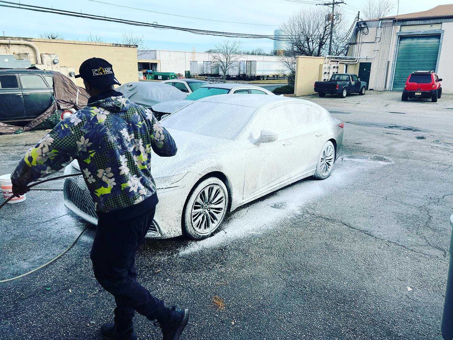 Employee cleanng the exterior of a Lexus sedan